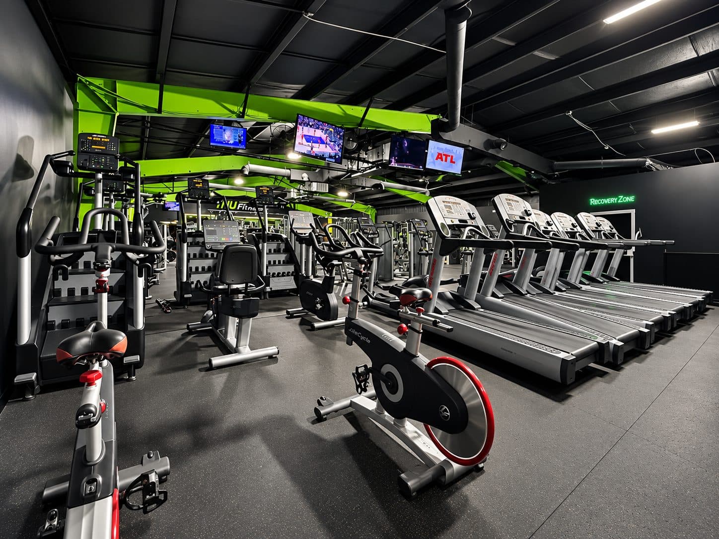Cardio floor with wall-mounted televisions at TNU Fitness