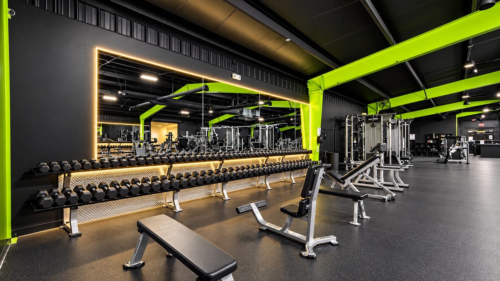 Full dumbbell rack running the length of the wall at TNU Fitness