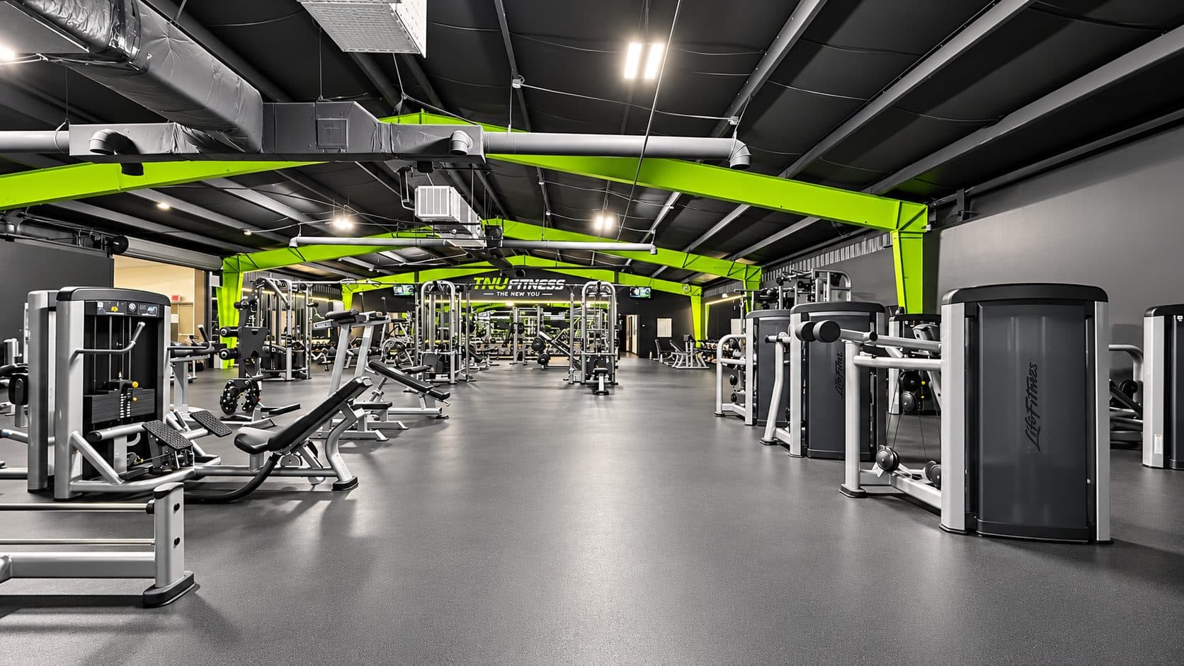 Row of selectorized strength machines at TNU Fitness