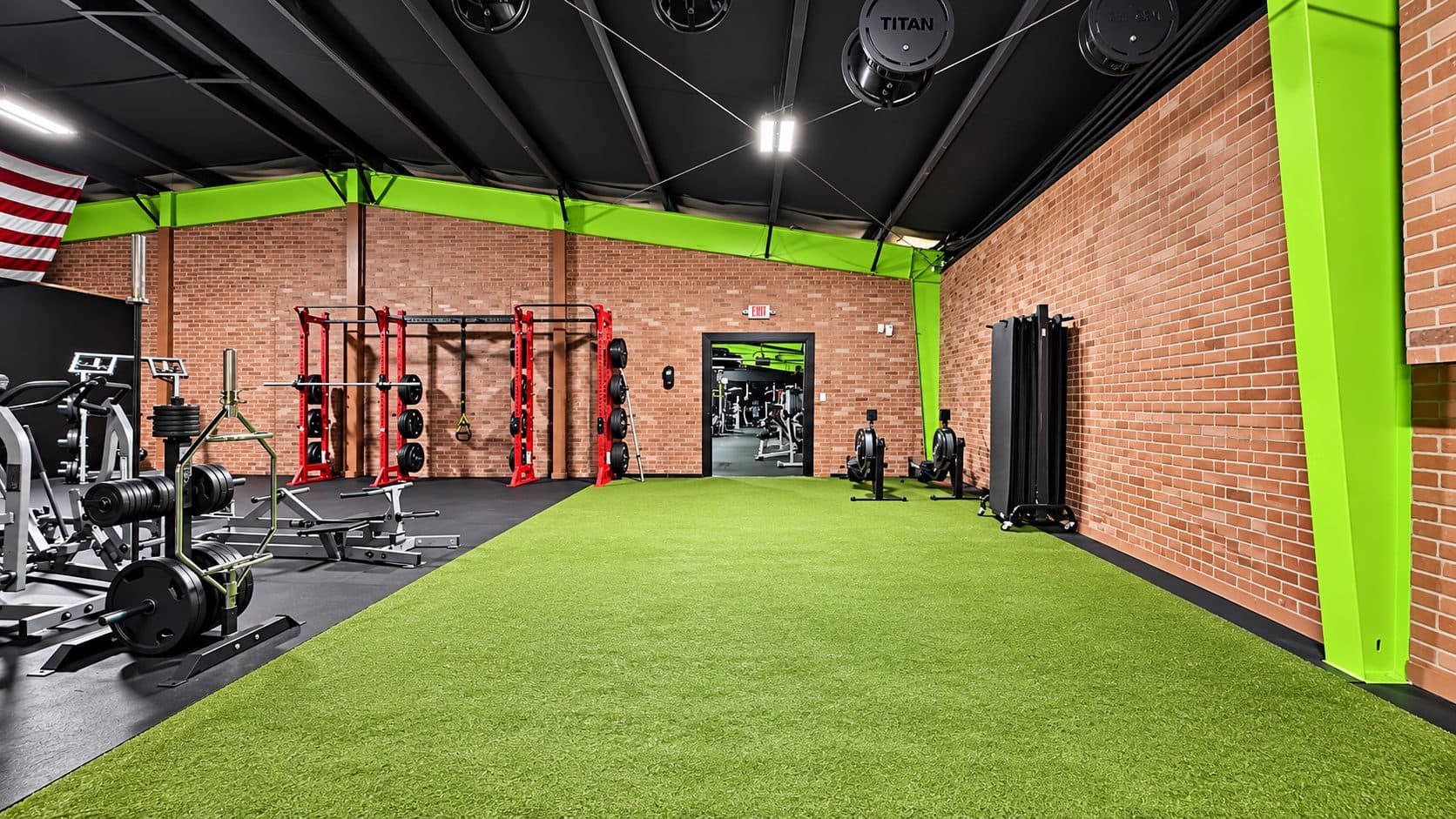 Turf area with squat racks and functional equipment at TNU Fitness
