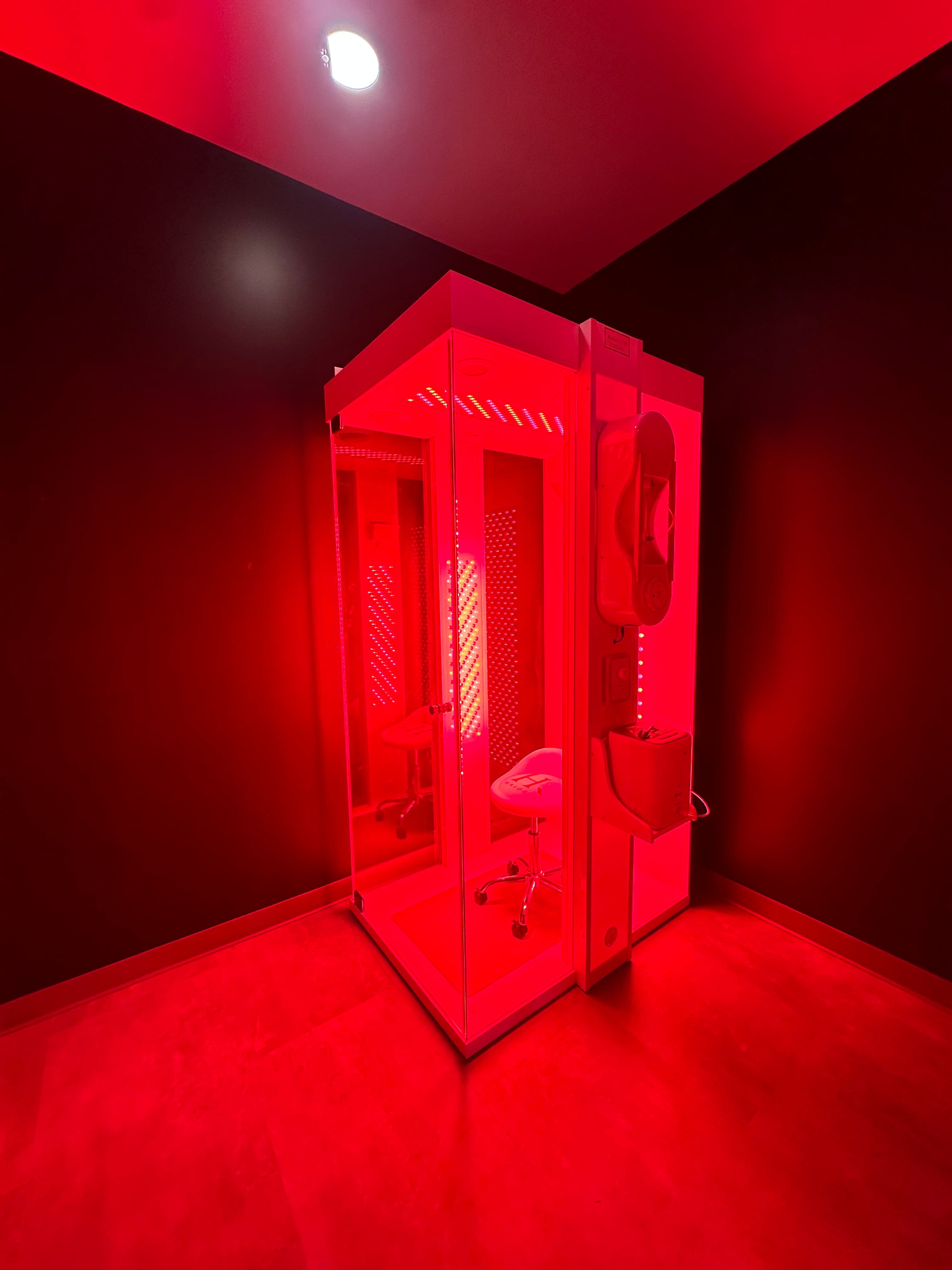 The HaloRed O₂ recovery booth lit with red light therapy panels
